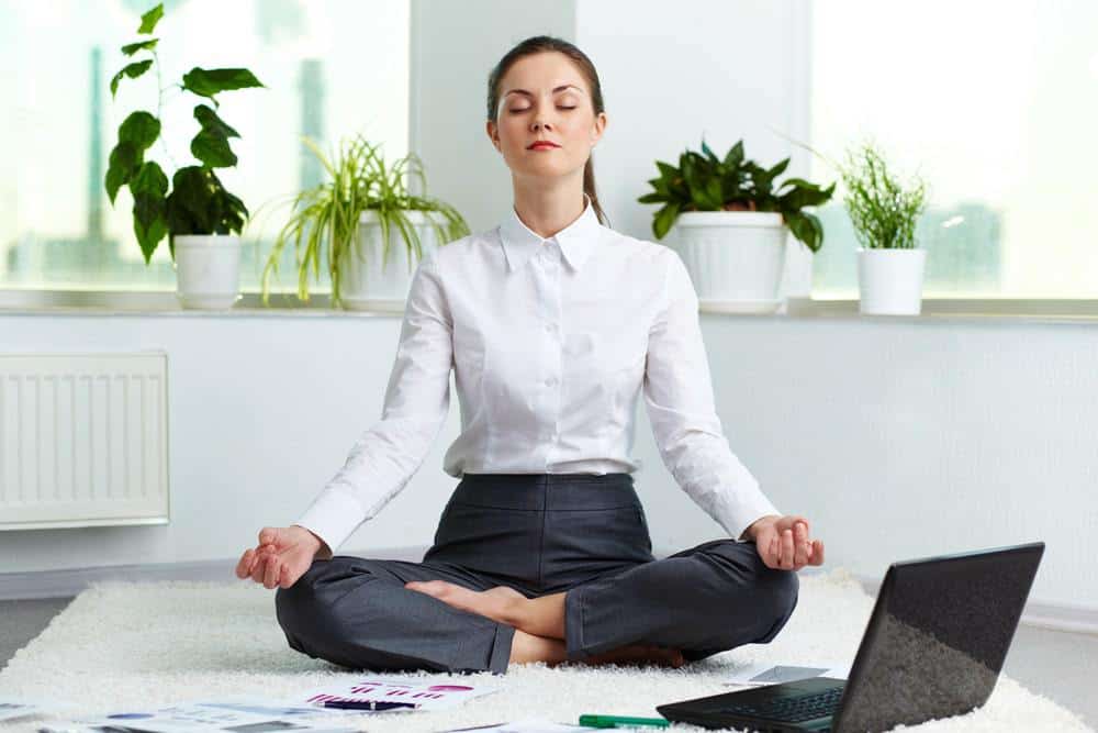young woman performing transcendental meditation in the work office